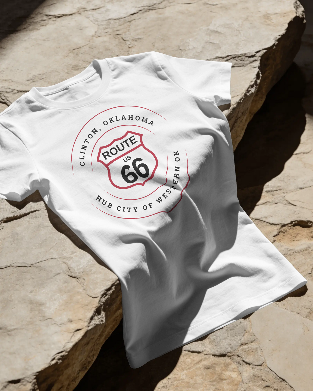 Clinton hub city Route 66 unisex tee in white, front view lifestyle flat lay