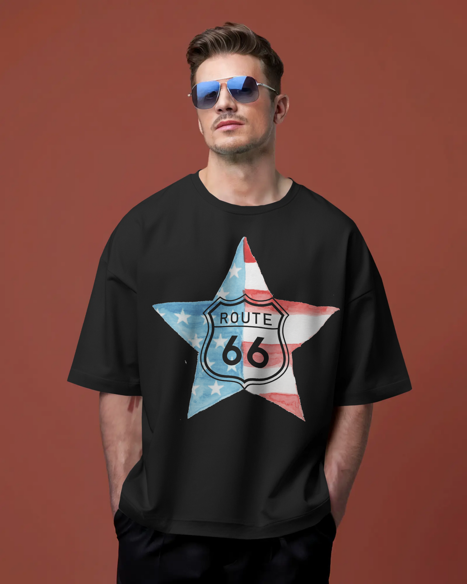 Man wearing a black Route 66 t-shirt with a patriotic star design, standing confidently against a rust-red background.