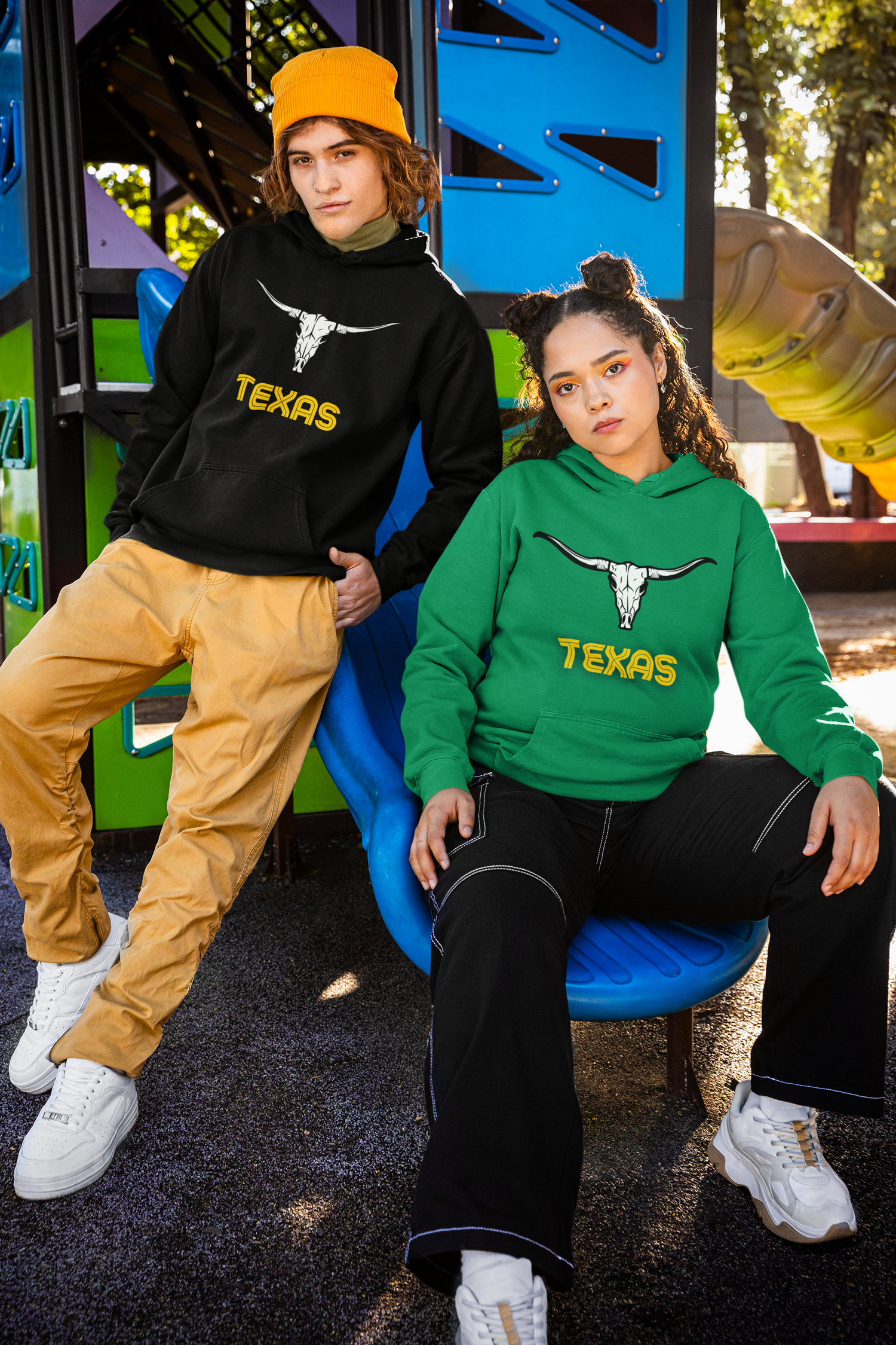 Two young models wearing Texas Longhorn hoodies in black and green, showcasing Route 66-inspired Western design