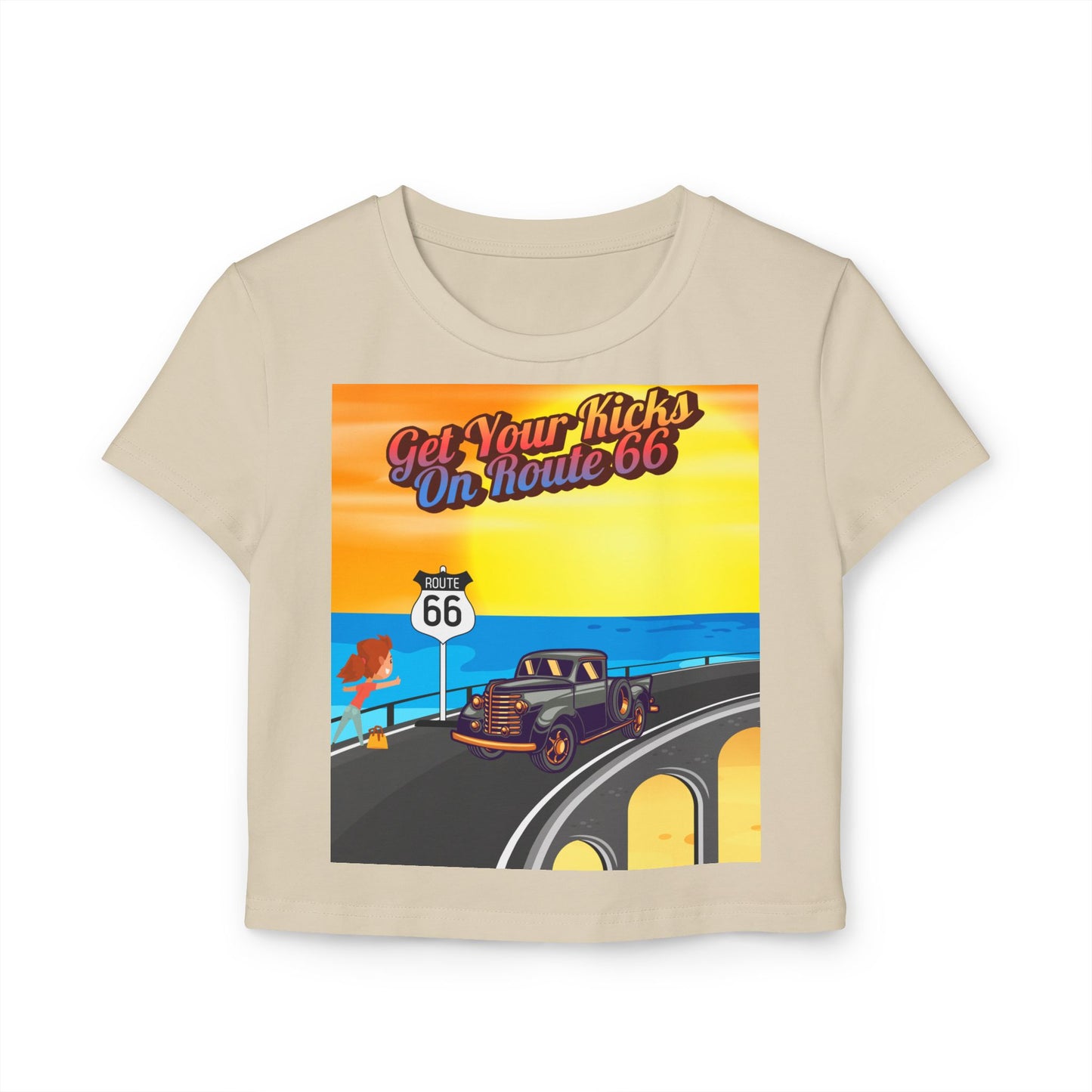 Flat lay of sand Retro Route 66 women’s baby tee featuring vintage highway design and “Get Your Kicks on Route 66” print.