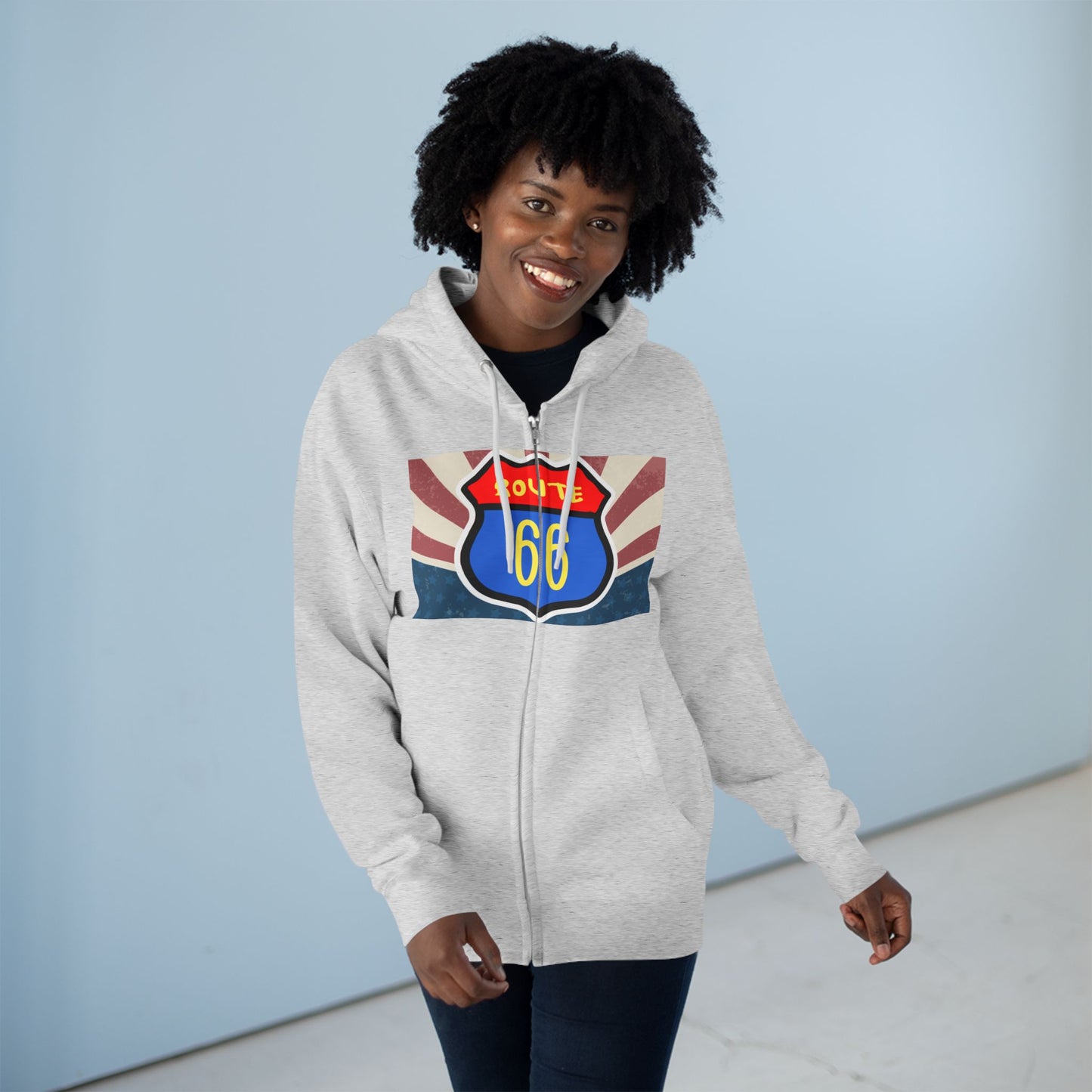 Smiling woman posing casually and wearing a heather grey Retro route 66 zip hoodie with a vintage highway graphic with the Route 66 shield.