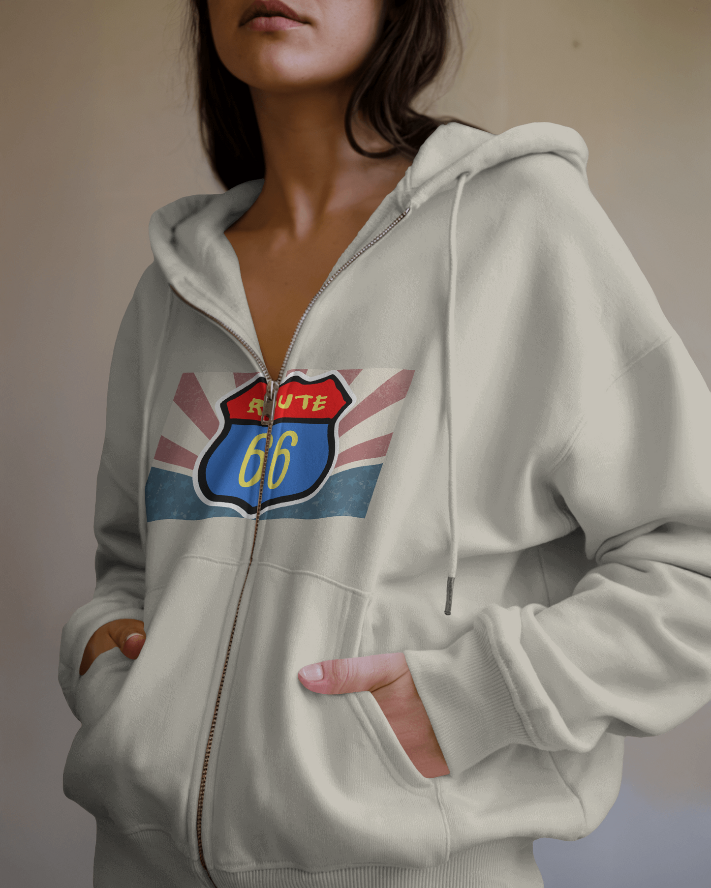 Woman wearing a oatmeal heather  Retro Route 66 zip hoodie, relaxed fit with vintage Americana travel graphic.
