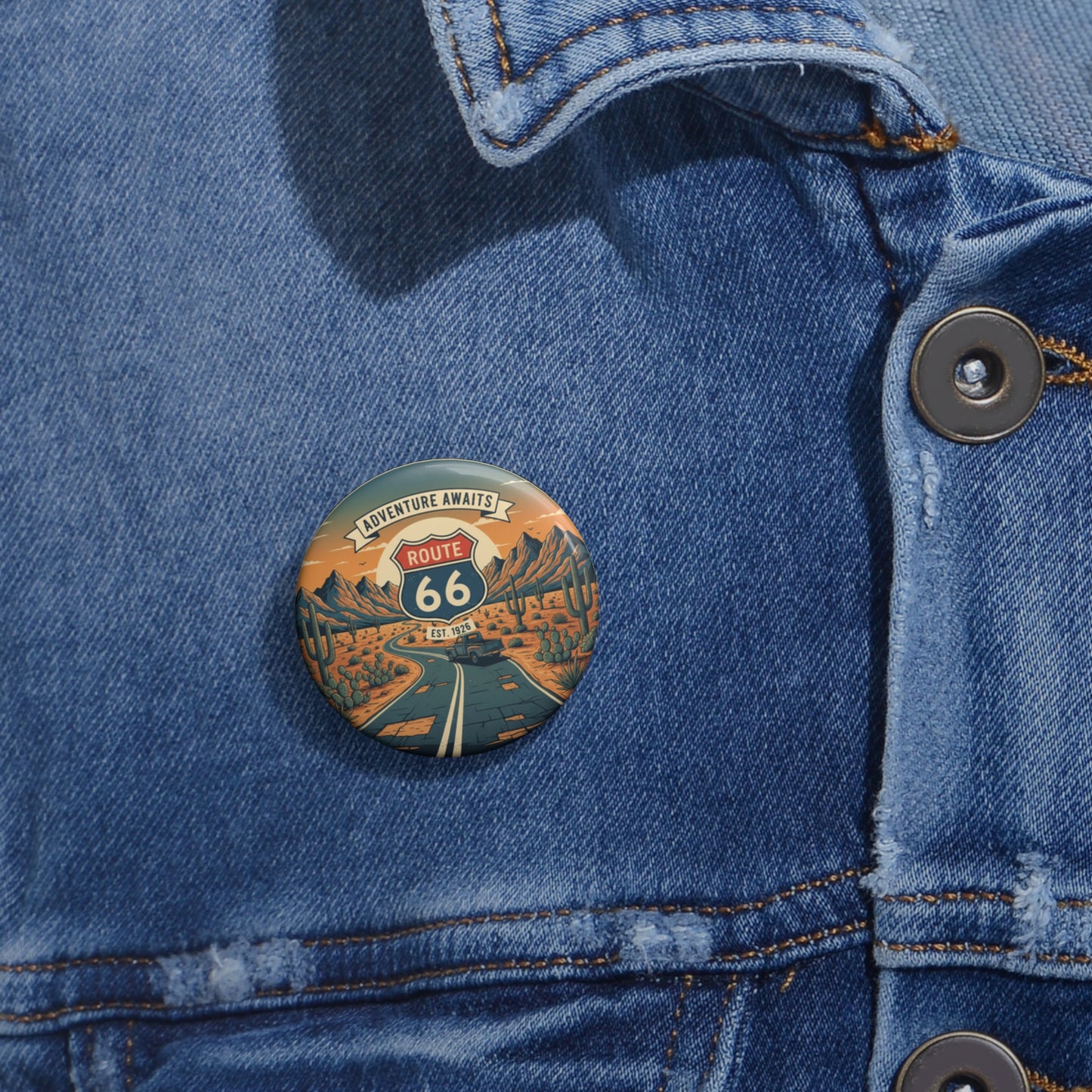 Route 66 'Adventure Awaits' pin button attached to a blue denim jacket.