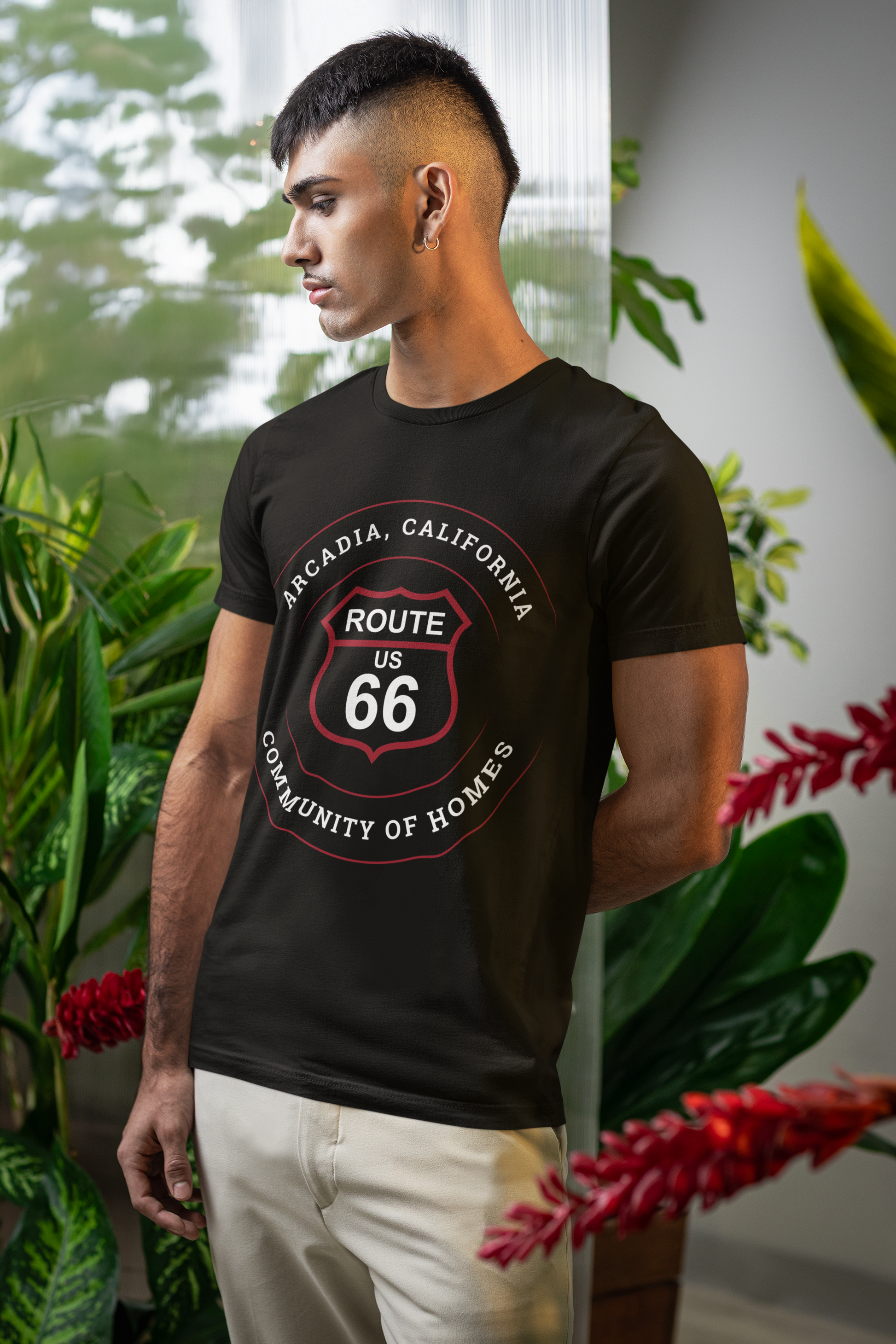 Male model looking off to the side and wearing a black retro Route 66 unisex jersey tee with Arcadia, CA: "Community of Homes" design