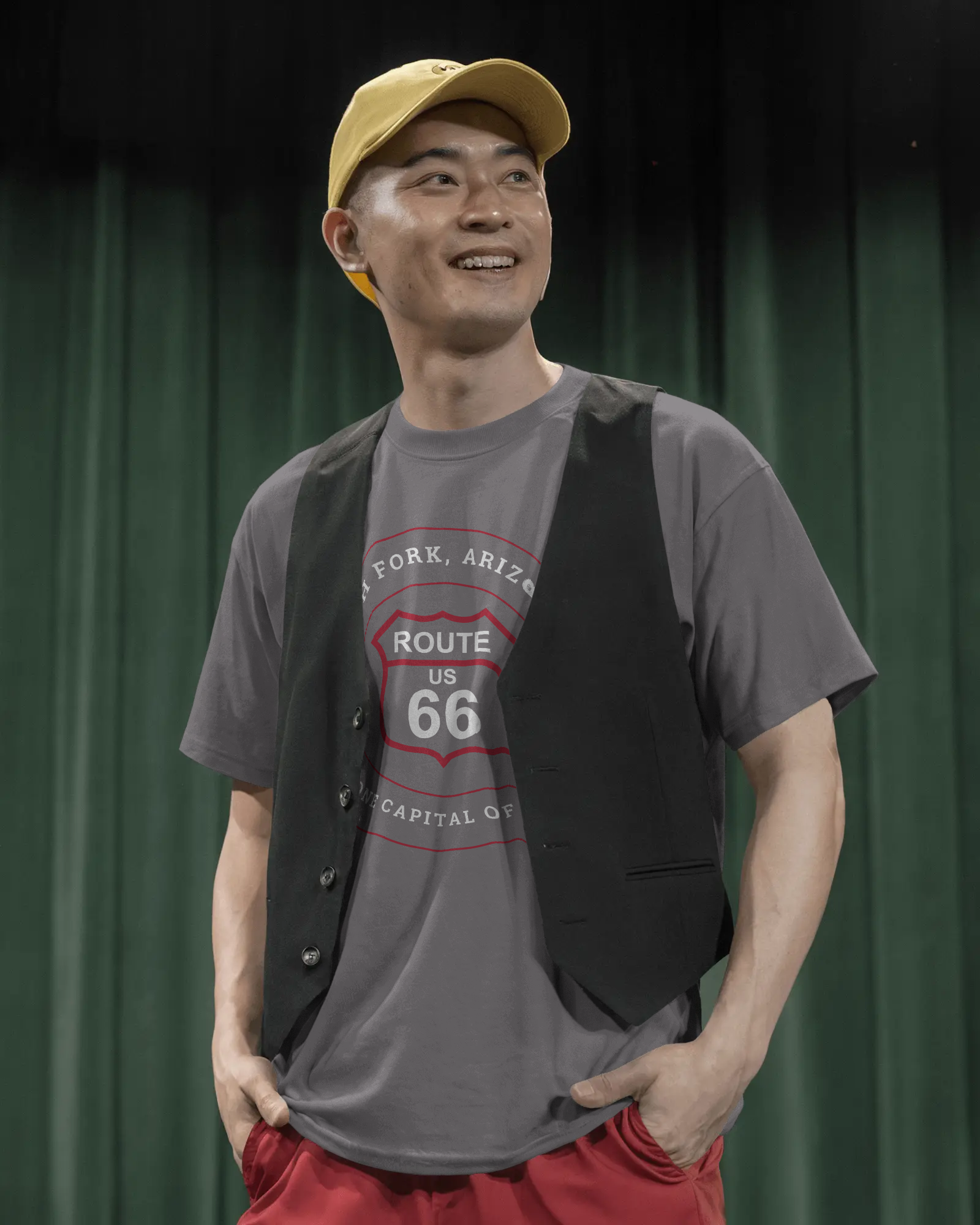 Male model wearing dark grey heather retro Route 66 unisex jersey tee with Ash Fork, AZ: "Flagstone Capital of the World" design