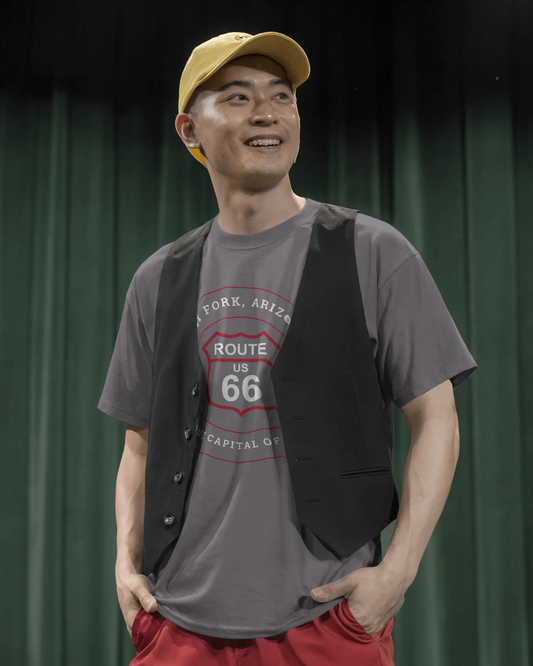 Male model wearing dark grey heather retro Route 66 unisex jersey tee with Ash Fork, AZ: "Flagstone Capital of the World" design