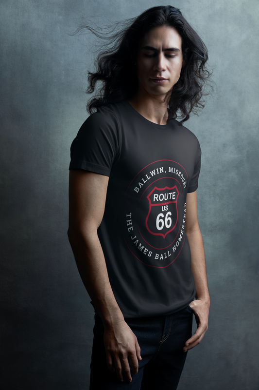 Male model with long dark hair who is wearing a black heather retro Route 66 unisex jersey tee with a Ballwin, MO: "The James Ball Homestead" design