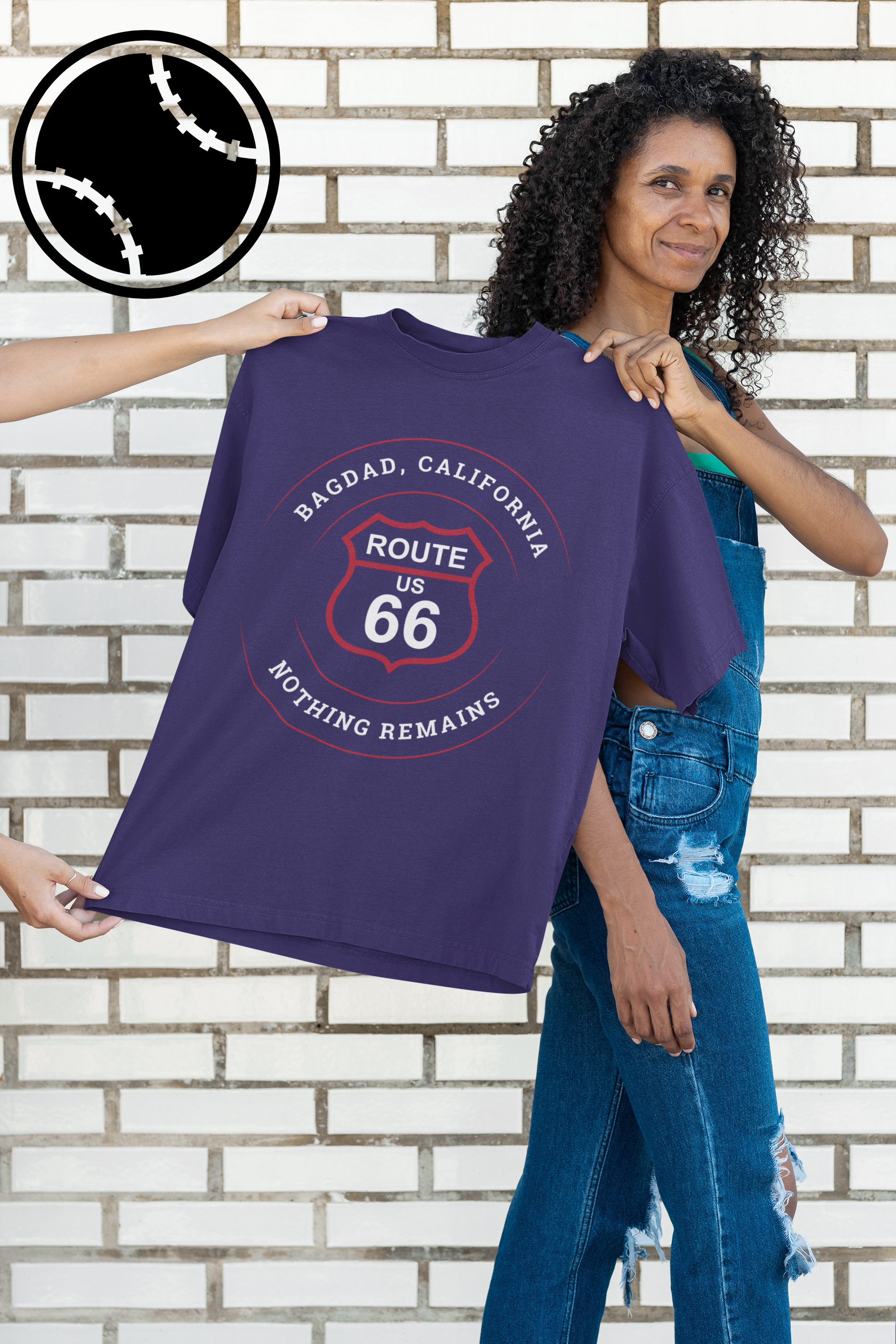 Female model holding a team navy retro Route 66 unisex jersey tee with Bagdad, CA: "Nothing Remains" design