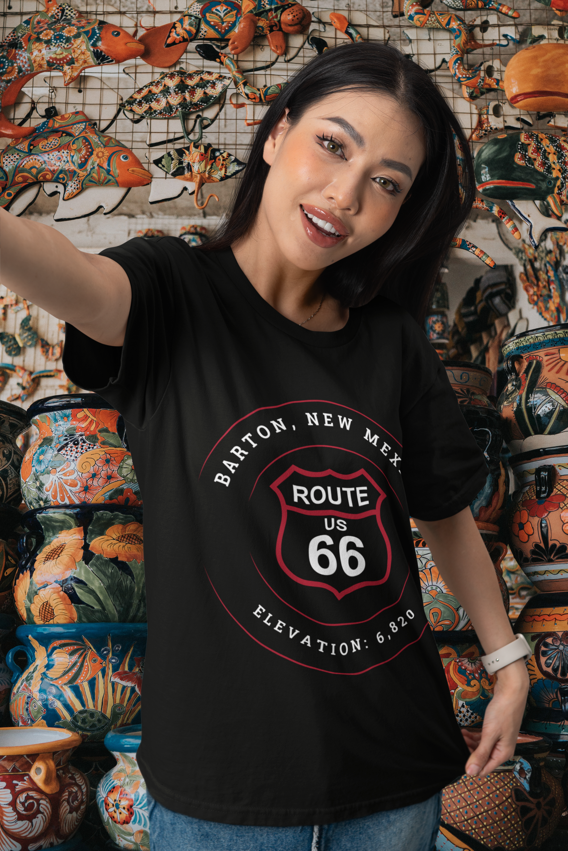 Female model wearing black retro Route 66 unisex jersey tee with Barton, NM: Elevation: 6,820 graphic