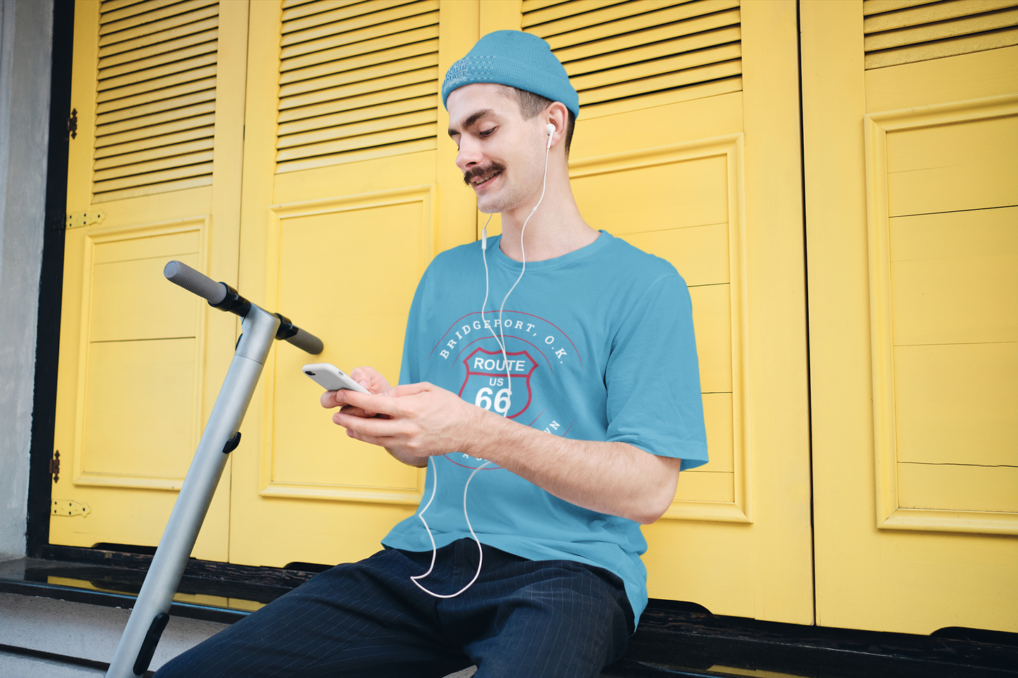 Male model wearing turquoise retro Route 66 unisex jersey tee with Bridgeport, OK "Almost a Ghost Town" design