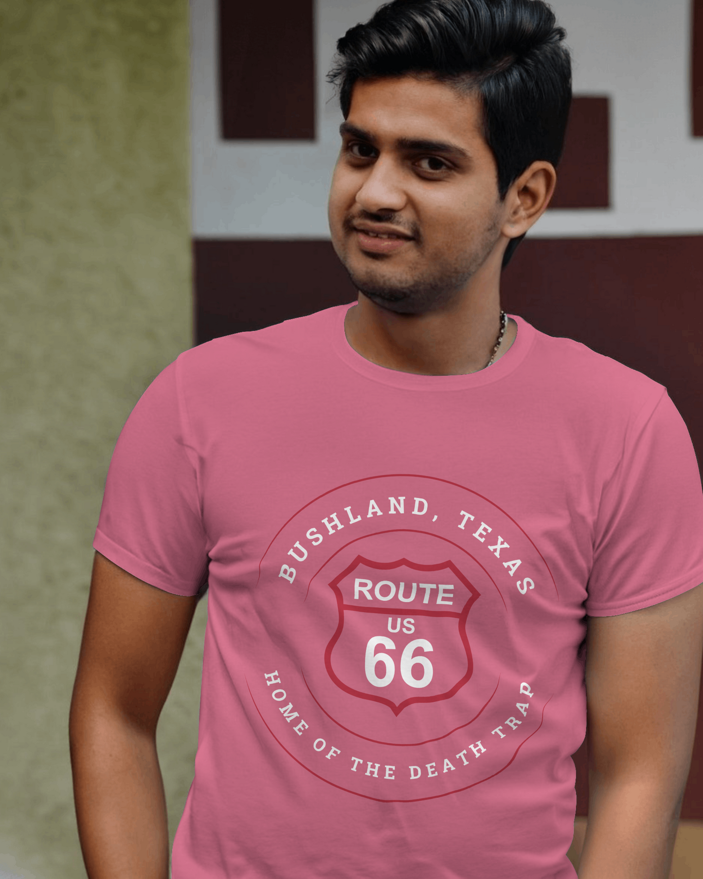 Male model wearing heather raspberry retro Route 66 unisex jersey tee with Bushland, TX: "Home of the Death Trap" design