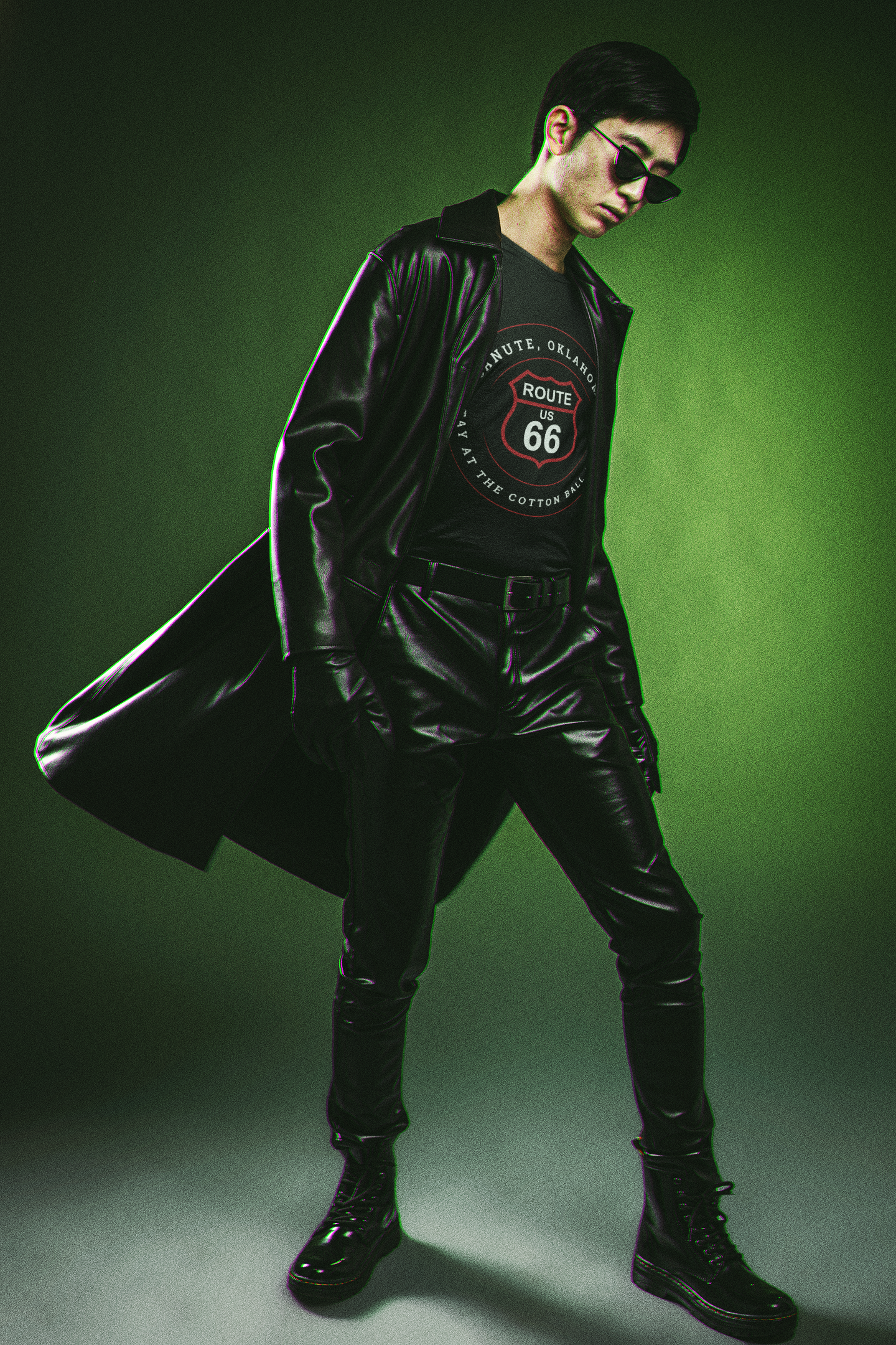 Male model wearing a black leather jacket and a black retro Route 66 unisex jersey tee with Canute, OK "Stay at the Cotton Ball Motel" design with a Matrix-style background