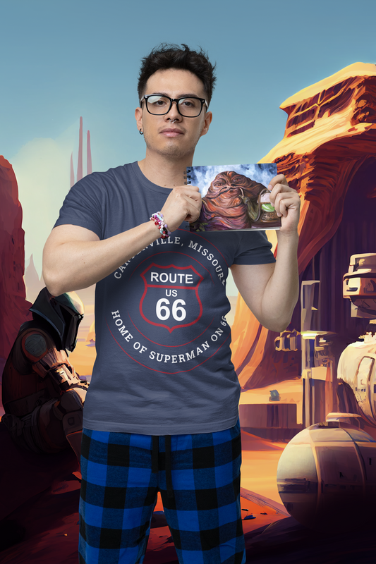 Male model holding an original painting by Route 66 artist Krizzart of Jabba the Hut smoking a hookah. He is wearing a heather true royal retro Route 66 unisex jersey tee with Carterville, MO "Home of Superman on 66" design and blue and black pajamas. He is standing in Tatooine with a Mandalorian sitting behind him