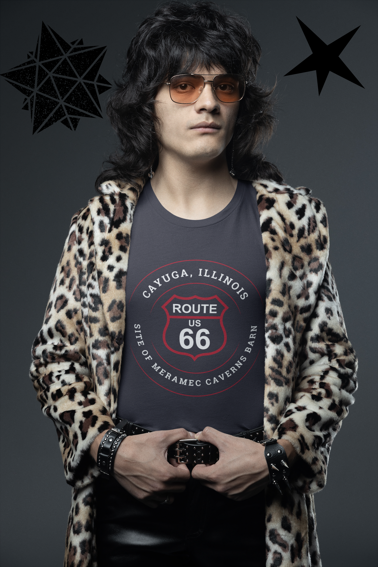 Male model wearing a black retro Route 66 unisex jersey tee with a Cayuga, IL: "Site of Meramec Caverns Barn" design