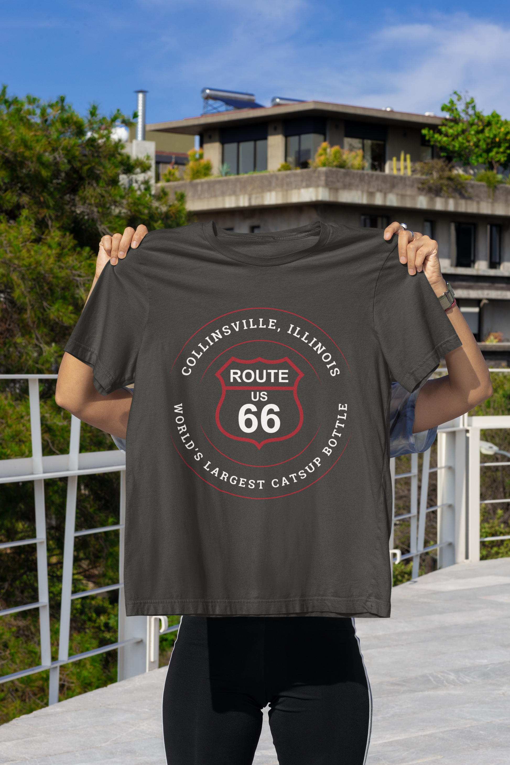 Hidden model holding a vintage black retro Route 66 unisex jersey tee with a Collinsville, IL:: "World's Largest Catsup Bottle" design which is covering her face and body