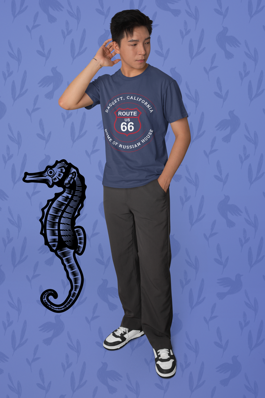 Male model wearing heather navy retro Route 66 unisex jersey tee with Daggett, CA: "Home of Russian House" design and standing next to a seahorse graphic