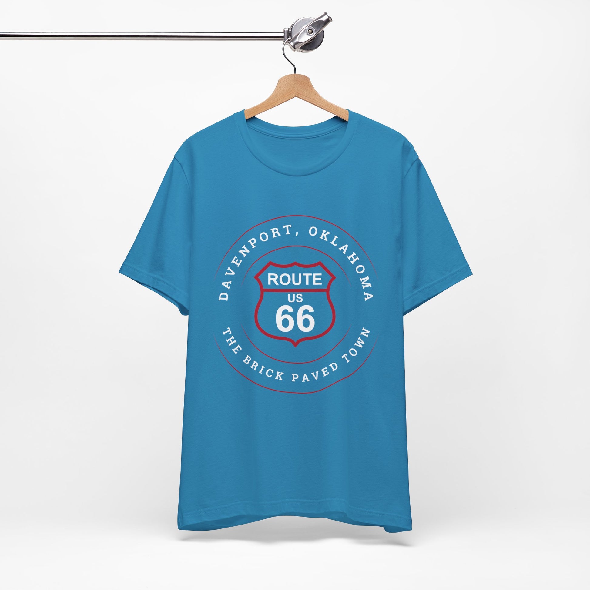 Aqua retro Route 66 unisex jersey tee with Davenport, OK "The Brick-Paved Town" design displayed on a wooden hanger