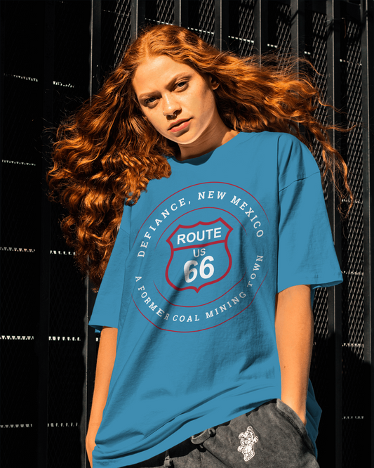 Female model wearing aqua retro Route 66 unisex jersey tee with Defiance, NM: A Former Coal Mining Town graphic