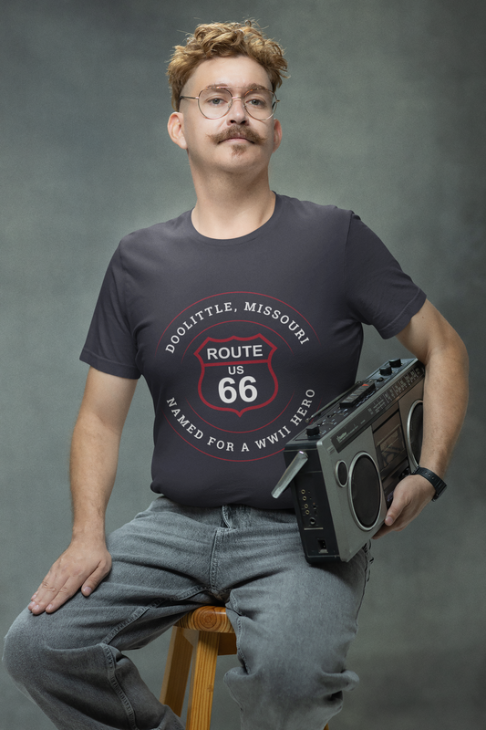 Male model holding a boombox and wearing a vintage black retro Route 66 unisex jersey tee with a Doolittle, MO: "Named for a WWII Hero" design