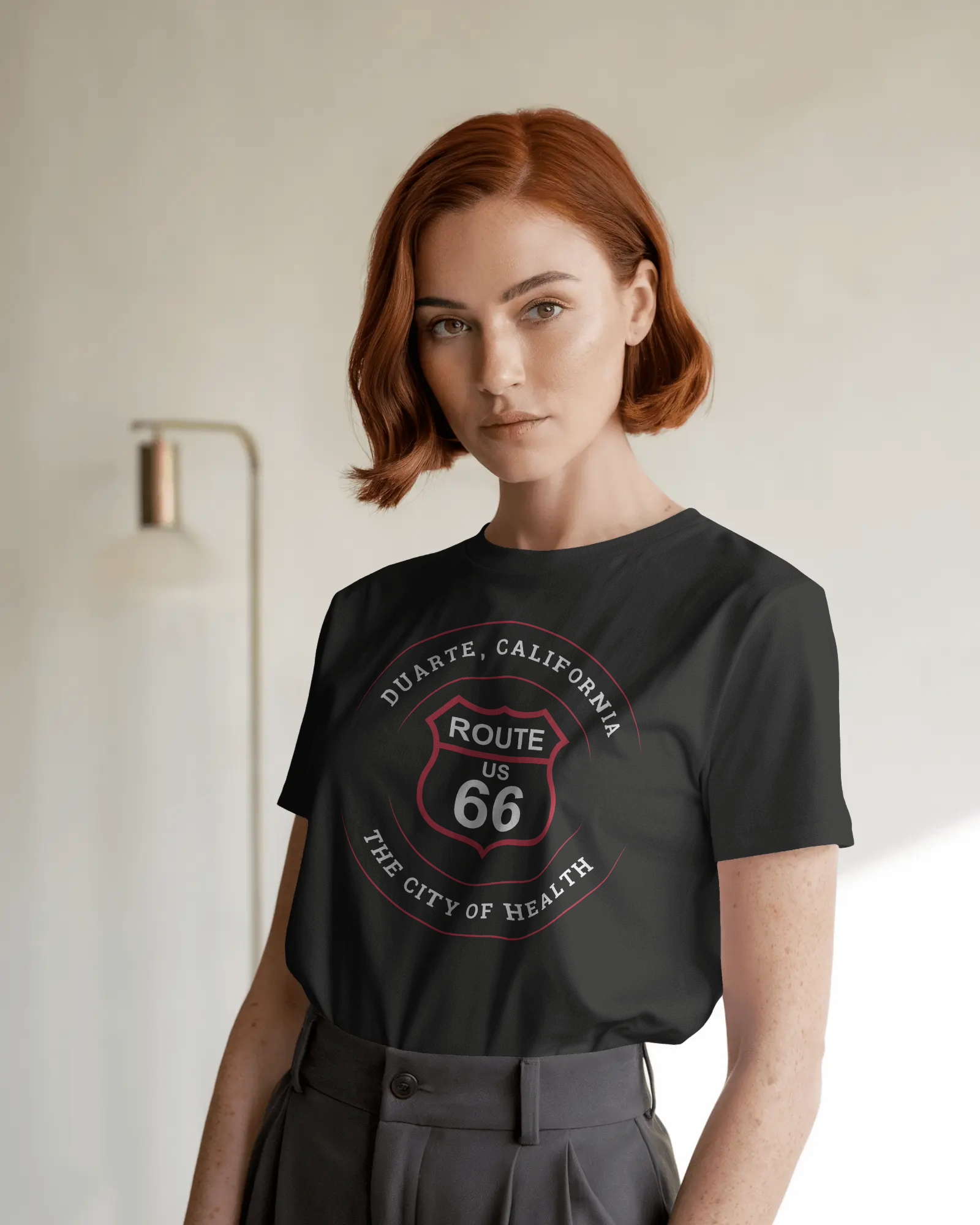 Female model wearing black heather retro Route 66 unisex jersey tee with Duarte, CA: "The City of Health" design