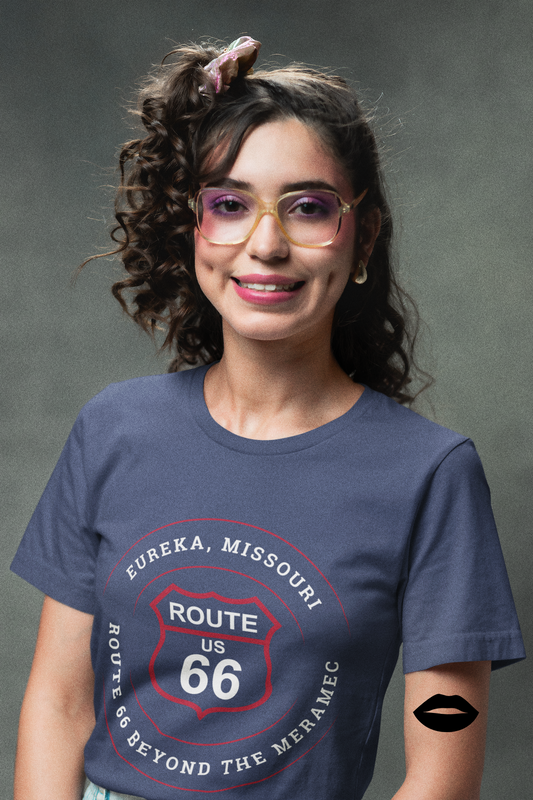 Female model wearing a heather true royal retro Route 66 unisex jersey tee with a Eureka, MO: "Route 66 Beyond the Meramec" design