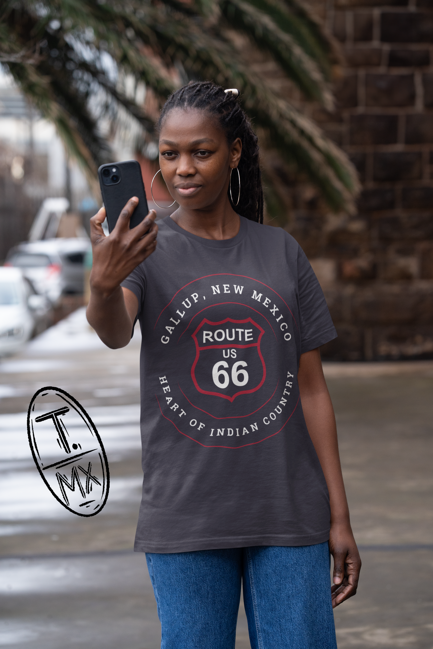 Female model wearing dark grey heather retro Route 66 unisex jersey tee with Gallup, NM: "Heart of Indian Country" design