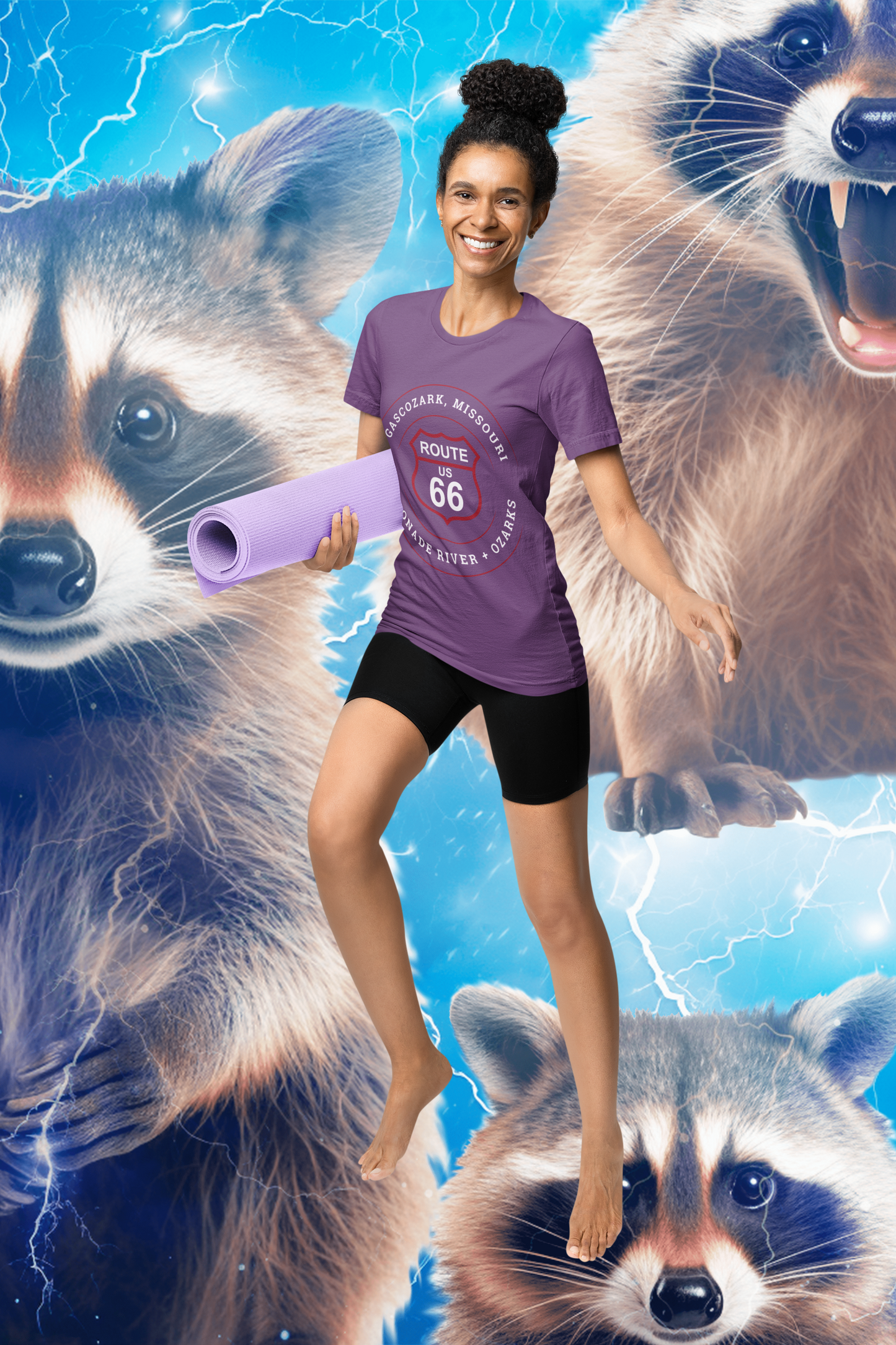Female model standing behind a raccoon electric background and wearing a heather team purple retro Route 66 unisex jersey tee with a Gascozark, MO "Gasconade River + Ozark" design