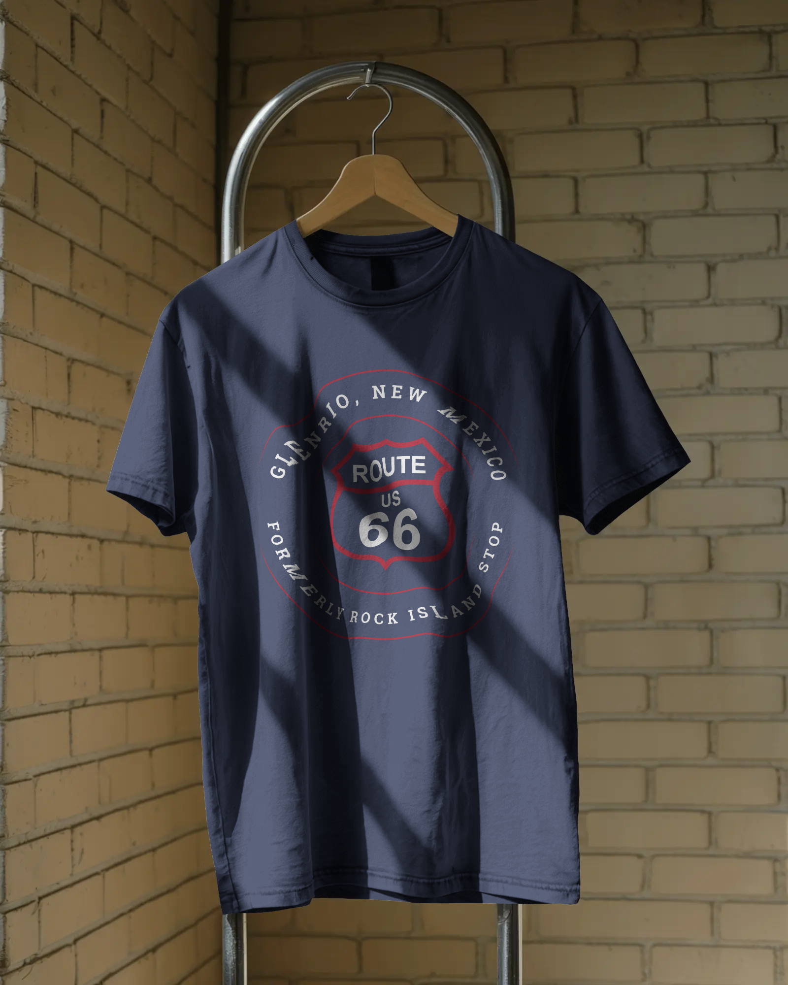 A heather true royal retro Route 66 unisex jersey tee with Glenrio, NM: "Formerly Rock Island" design hanging on a wooden hanger