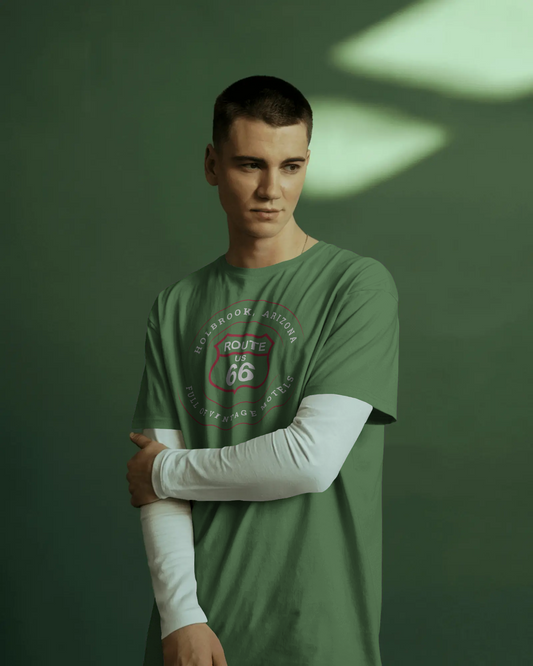 Male model wearing heather military green retro Route 66 unisex jersey tee with Holbrook, AZ: "Full of Vintage Motels" design