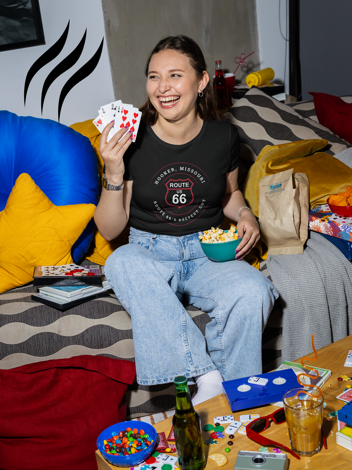 Female model wearing a black retro Route 66 unisex jersey tee with a Hooker, MO: "Route 66's Deepest Cut" design