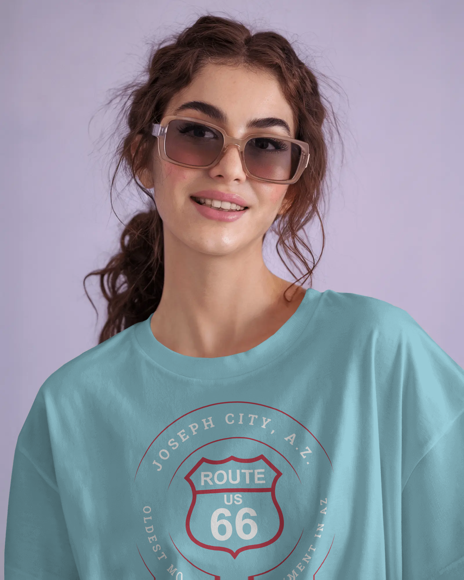 Female model wearing turquoise retro Route 66 unisex jersey tee with Joseph City, AZ: "Oldest Mormon Settlement in AZ" design