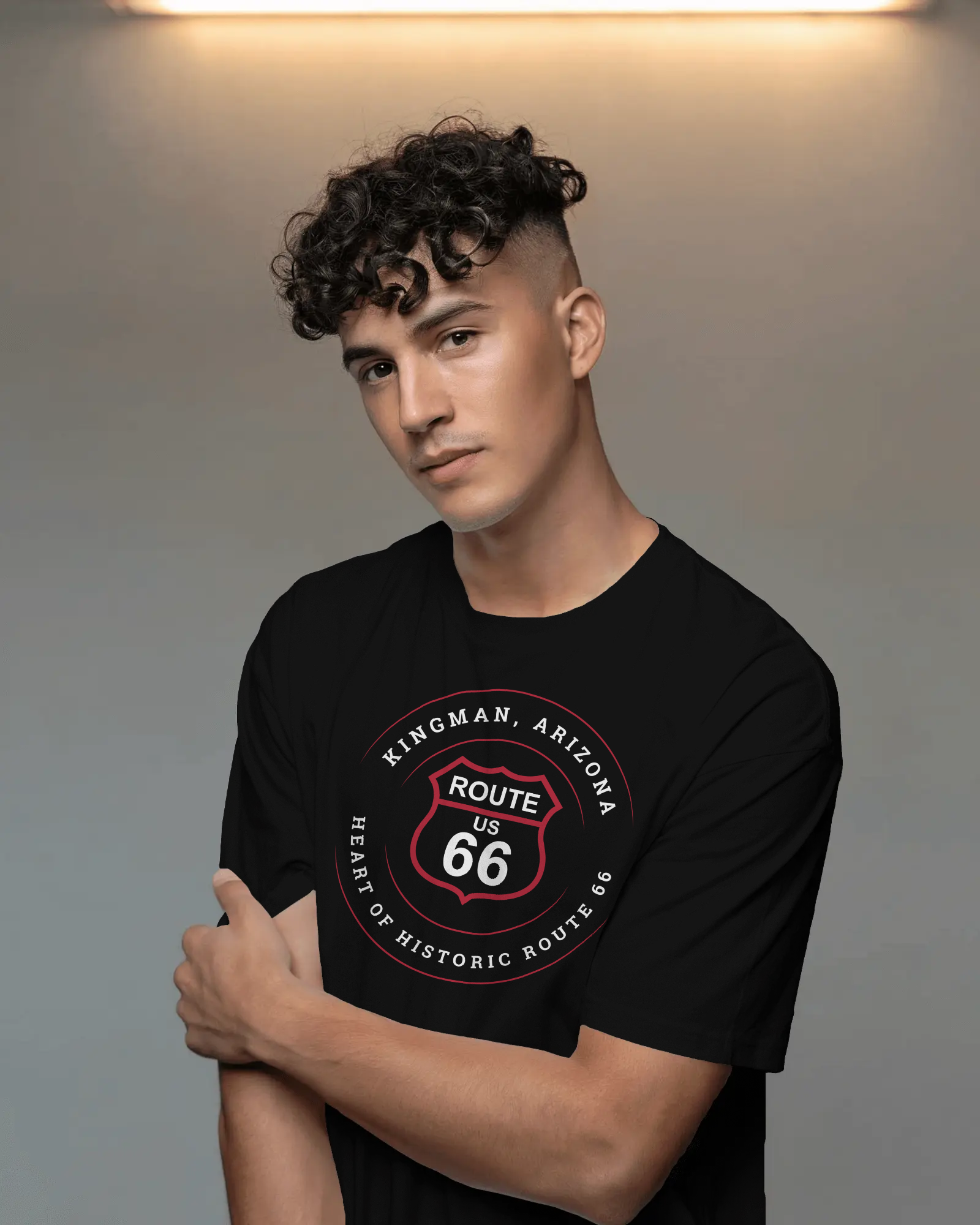 Male model wearing black retro Route 66 unisex jersey tee with Kingman, AZ: "Heart of Historic Route 66" design