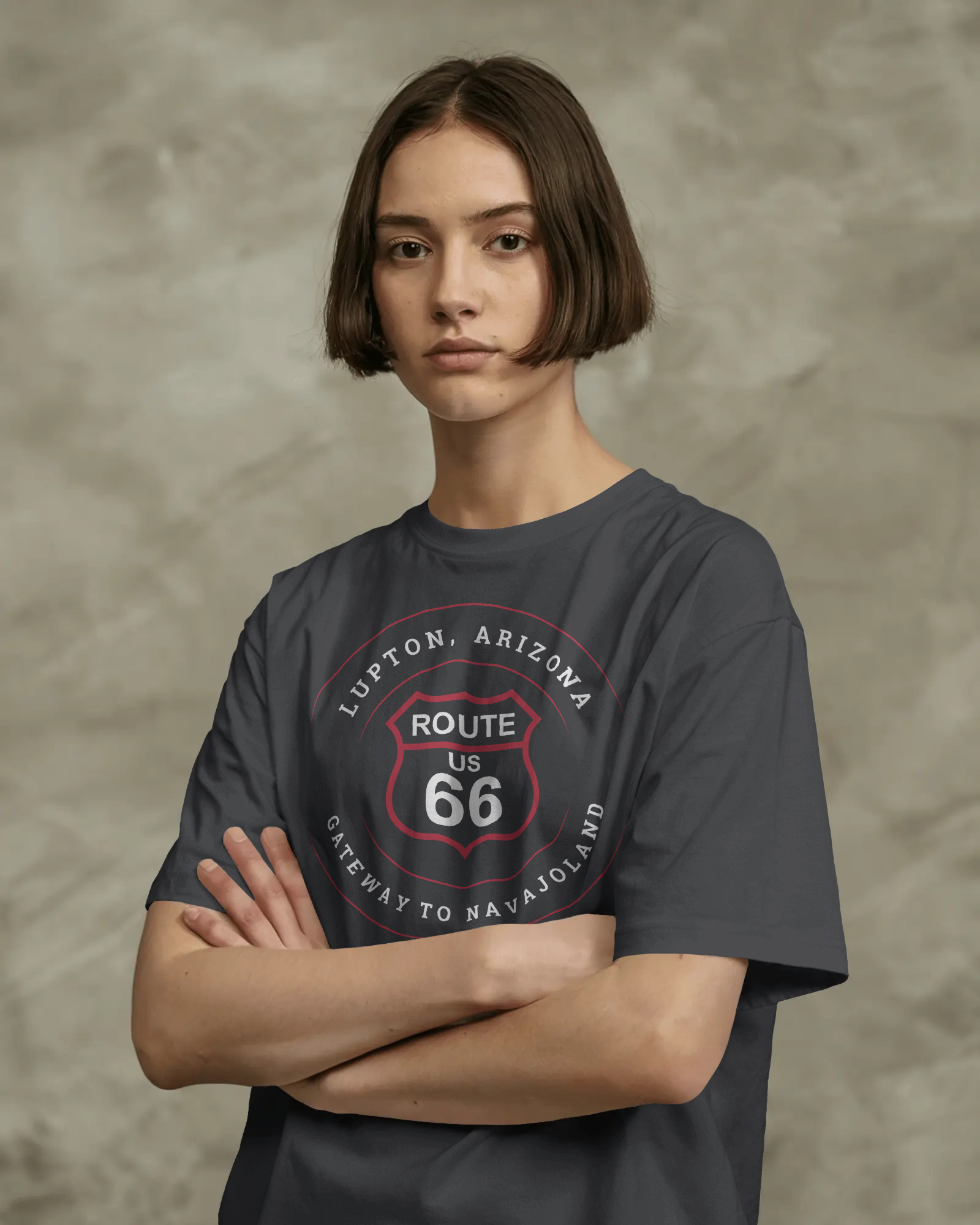 Female model wearing black heather retro Route 66 unisex jersey tee with Lupton, AZ: "Gateway to Navajoland" design