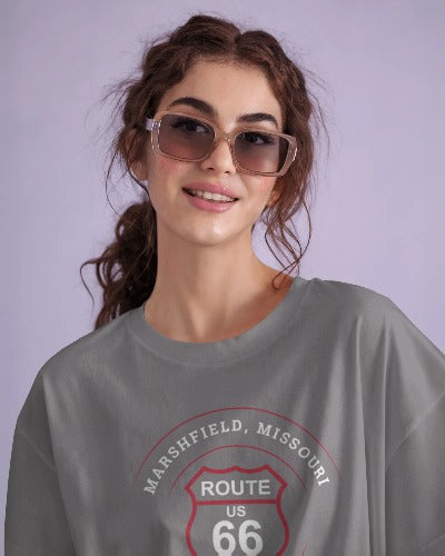 Female model wearing a grey retro Route 66 unisex jersey tee with a Marshfield, MO: "The Highest Town on Route 66" design