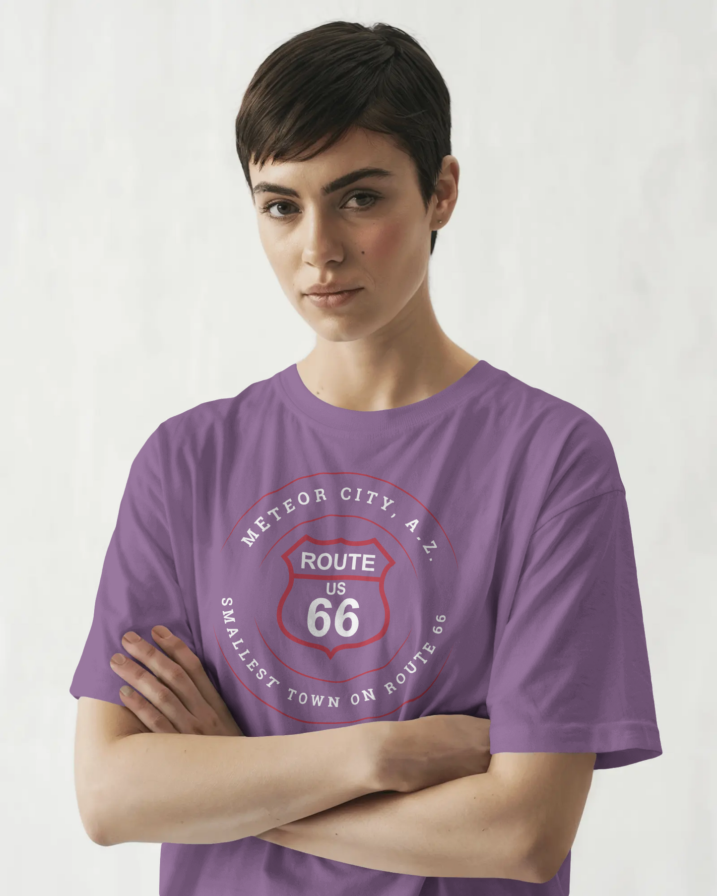 Female model wearing heather team purple retro Route 66 unisex jersey tee with Meteor City, AZ: "Smallest Town on Route 66" design
