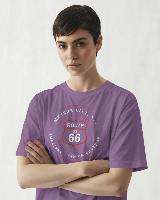 Female model wearing heather team purple retro Route 66 unisex jersey tee with Meteor City, AZ: "Smallest Town on Route 66" design