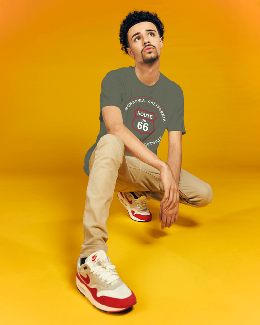Male model wearing heather military green retro Route 66 unisex jersey tee with Monrovia, CA: "Gem of the Foothills" design