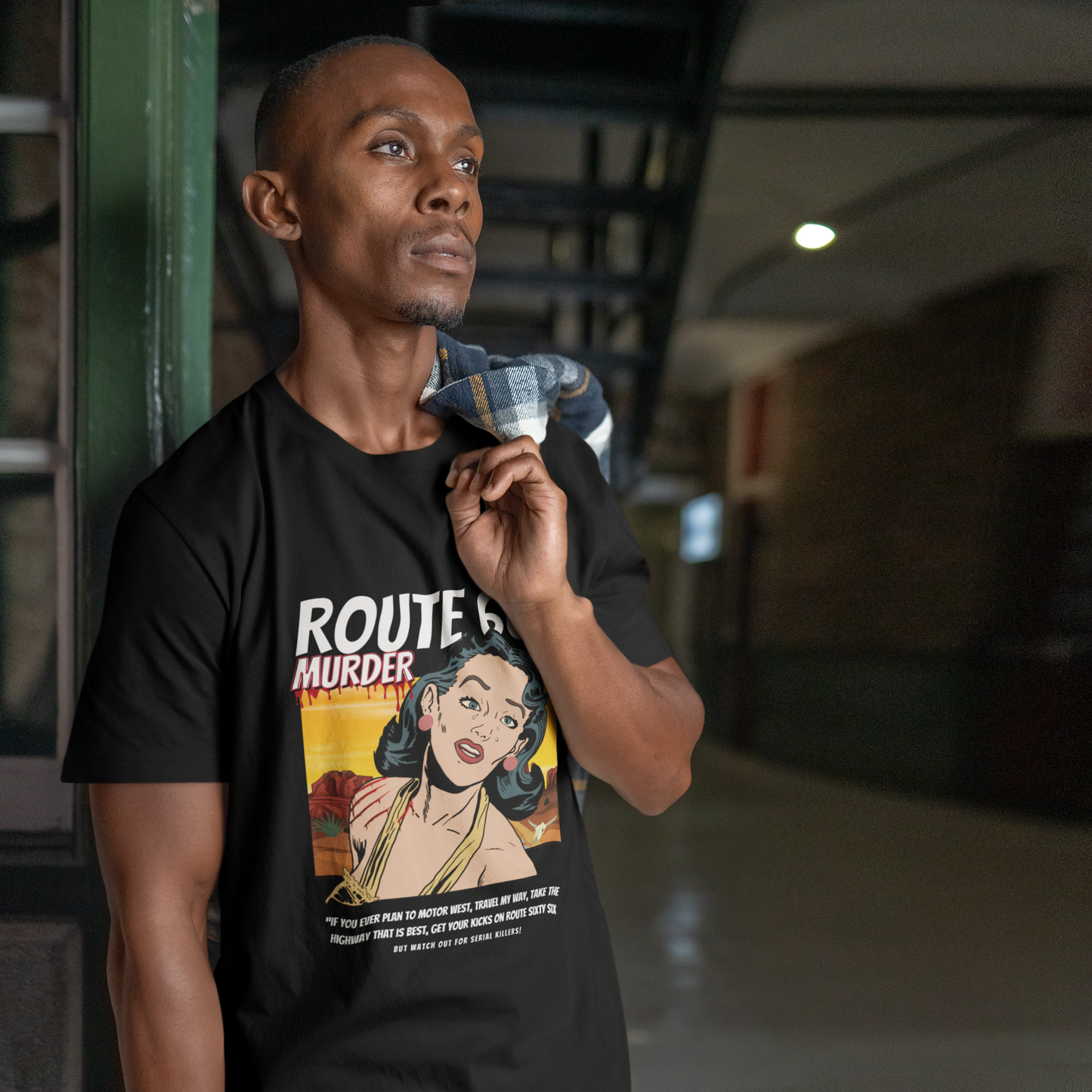 Male model wearing a black retro unisex jersey tee with a Route 66 murder comic book-style design