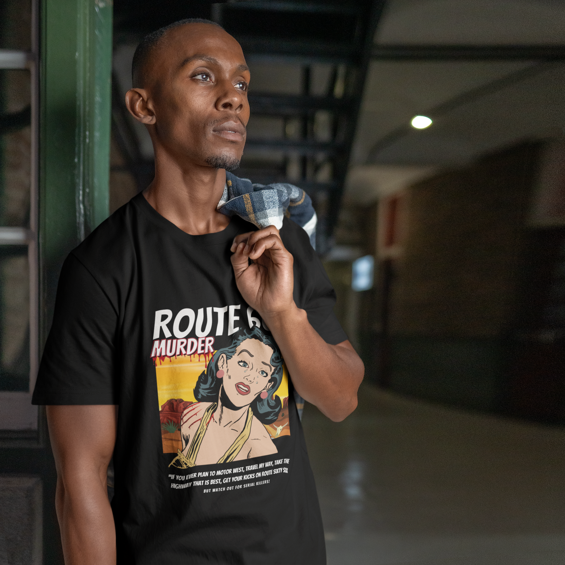 Male model wearing a black retro unisex jersey tee with a Route 66 murder comic book-style design