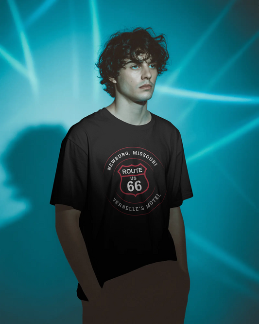 Male model wearing a black retro Route 66 unisex jersey tee with a Newburg, MO: "Vernelle's Motel" design