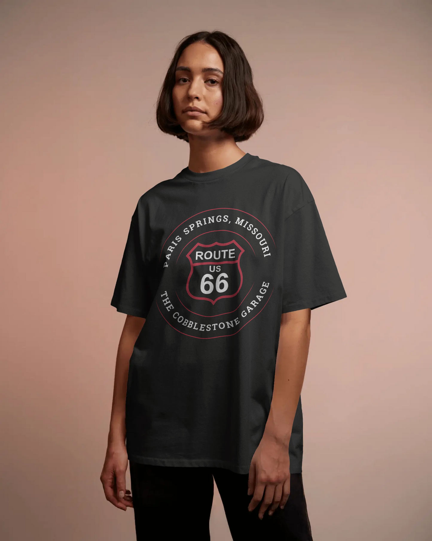 Female model wearing vintage black retro Route 66 unisex jersey tee with Paris Springs, MO "The Cobblestone Garage" design