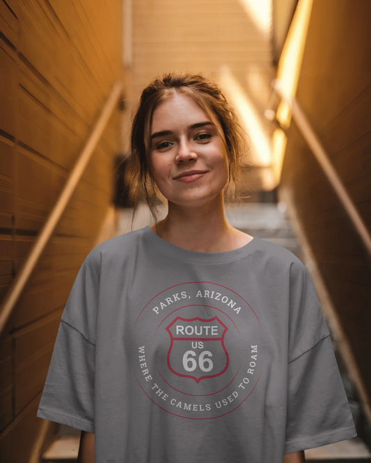 Female model wearing dark grey heather retro Route 66 unisex jersey tee with Parks, AZ: "Where the Camels Used to Roam" design