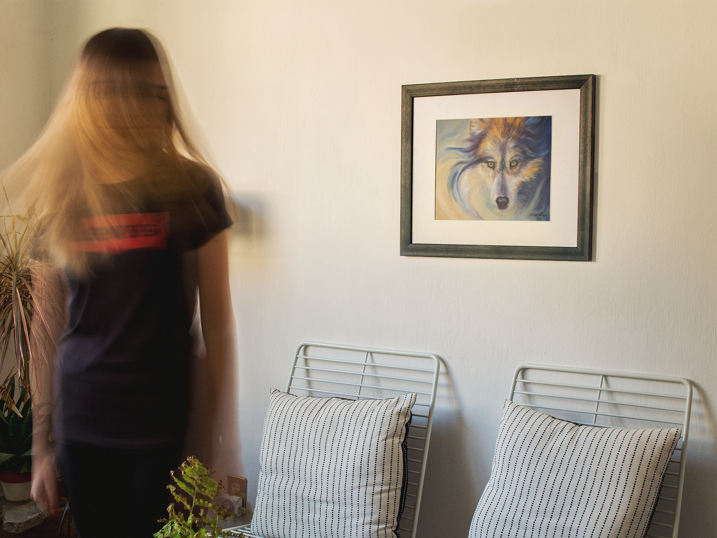 Woman turning from an expressionistic painting of a wolf's head with intense yellow eyes. The wolf's fur and the background are rendered in swirling, psychedelic brushstrokes of deep indigo, bright gold, lavender, and white, creating a sense of movement and "wild spirit."