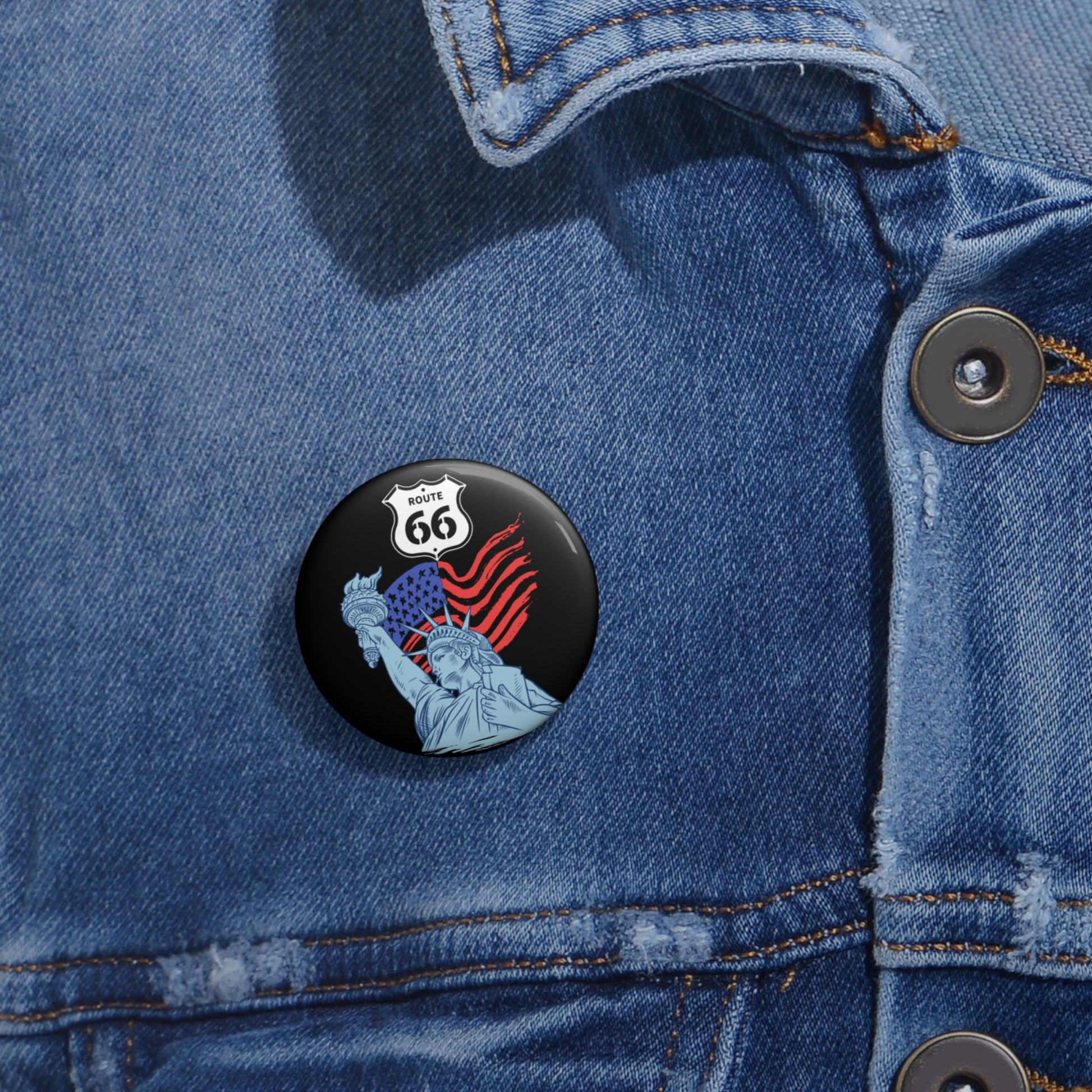 Route 66 Statue of Liberty pin button attached to a blue denim jacket.