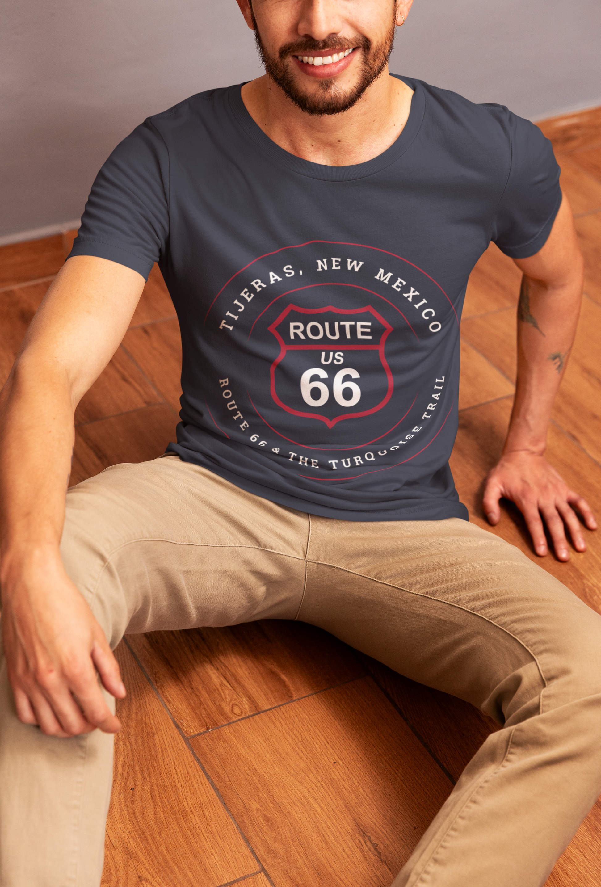 Male model wearing heather navy retro Route 66 unisex jersey tee with Tijeras, NM: "Route 66 and The Turquoise Trail" design