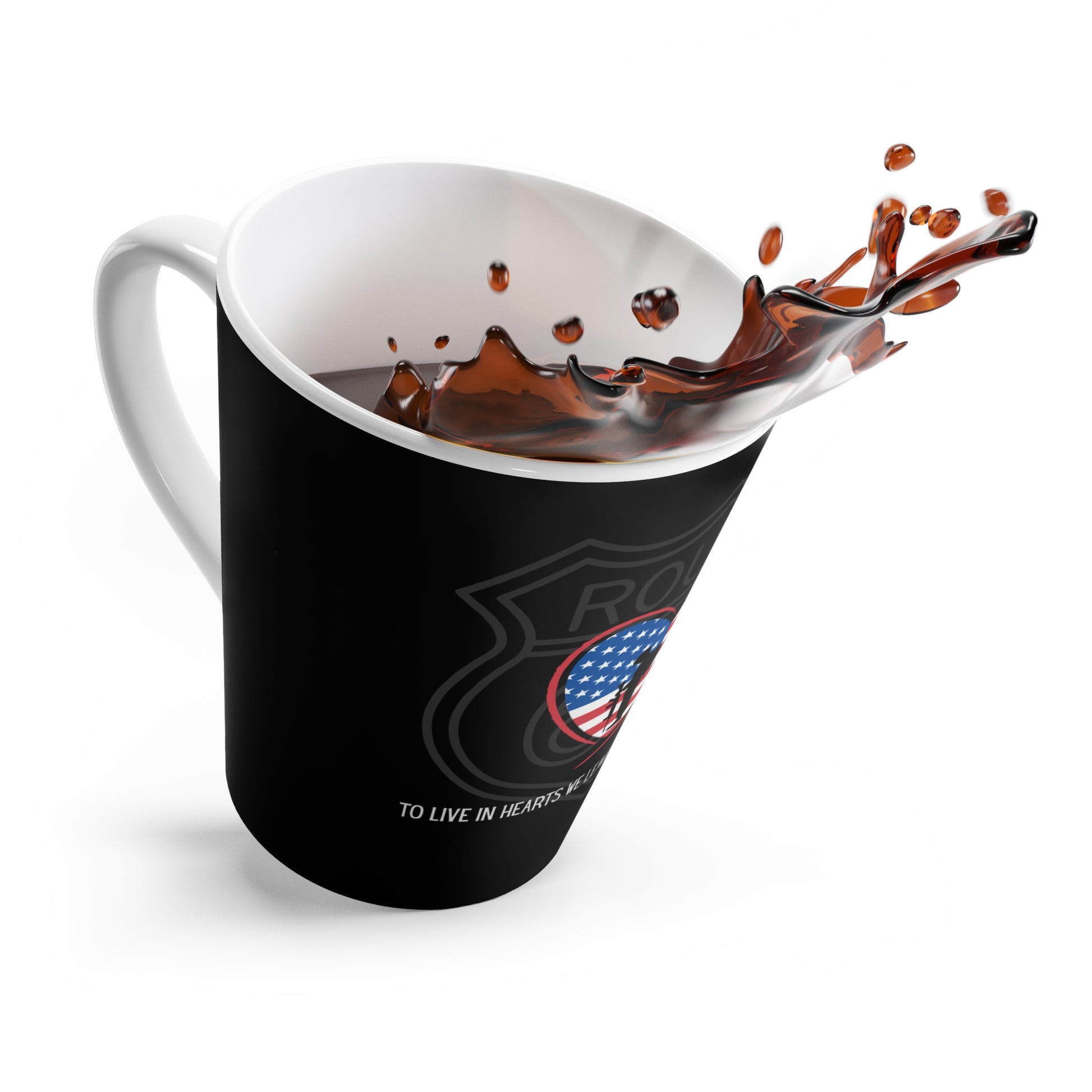 A dramatic, dynamic shot of a black, tapered black latte mug tilted to the side, with black coffee splashing high from the rim. The black latte mug features a Route 66 shield with a heart-shaped US flag, a and a Thomas Campbell quote.