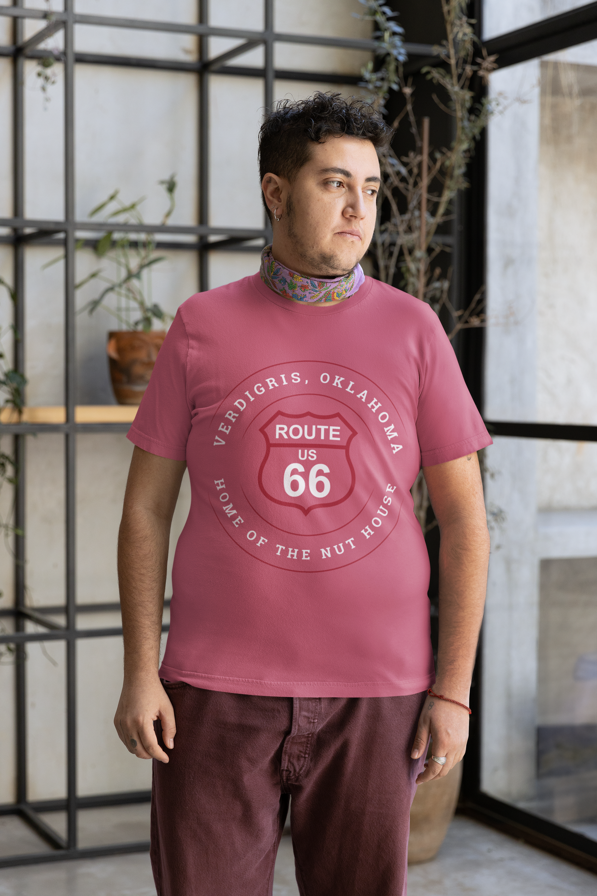 Male model wearing heather raspberry  retro Route 66 unisex jersey tee with Verdigris, OK "Home of the Nuthouse" design