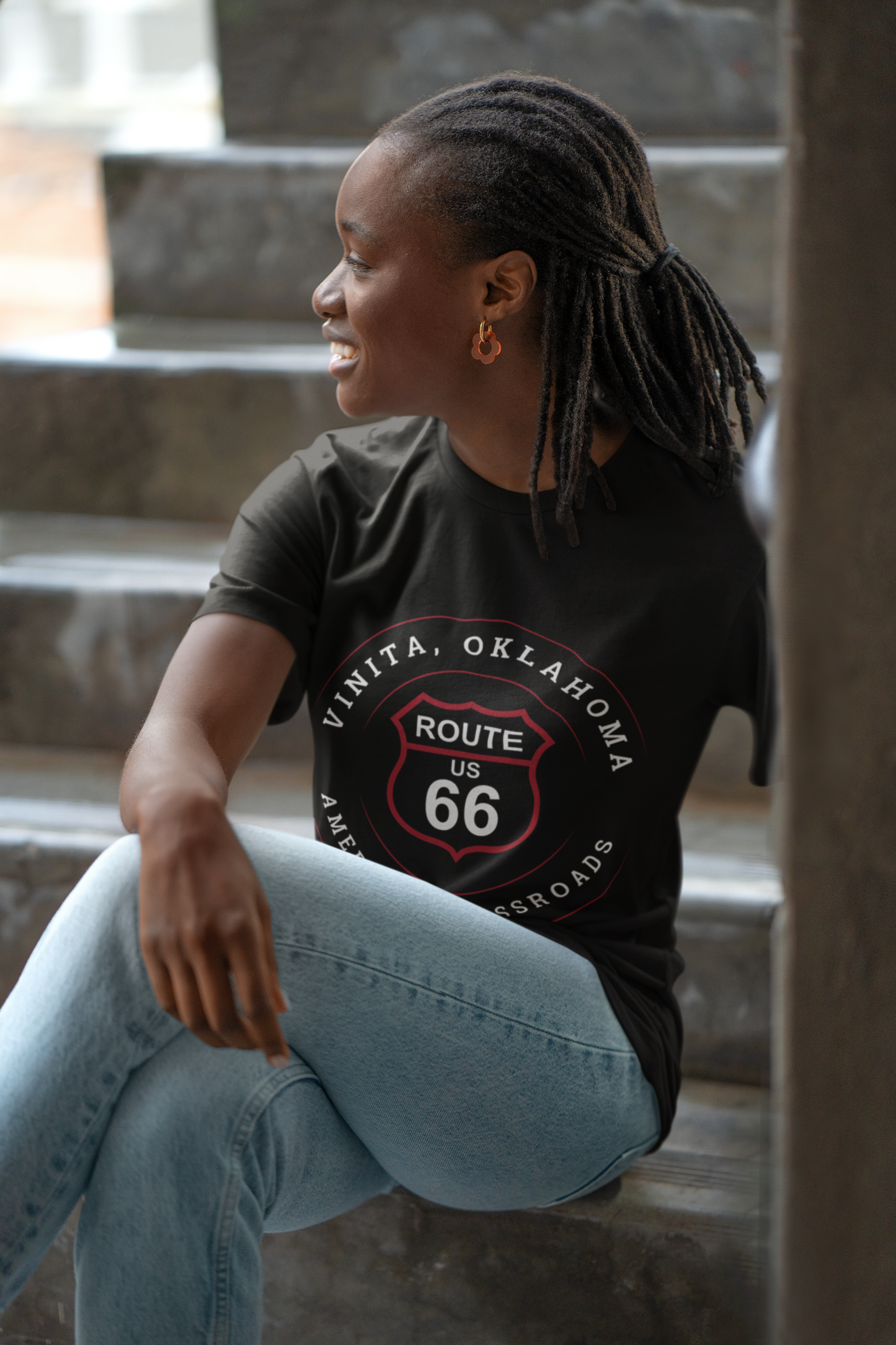 Female model wearing black heather retro Route 66 unisex jersey tee with Vinita, OK "America's Crossroads"  design