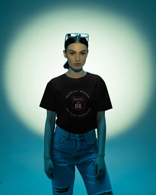 Woman wearing a black retro Route 66 unisex jersey tee with Wildwood, MO: "Big Chief Roadhouse" design tucked into her blue denim jeans.