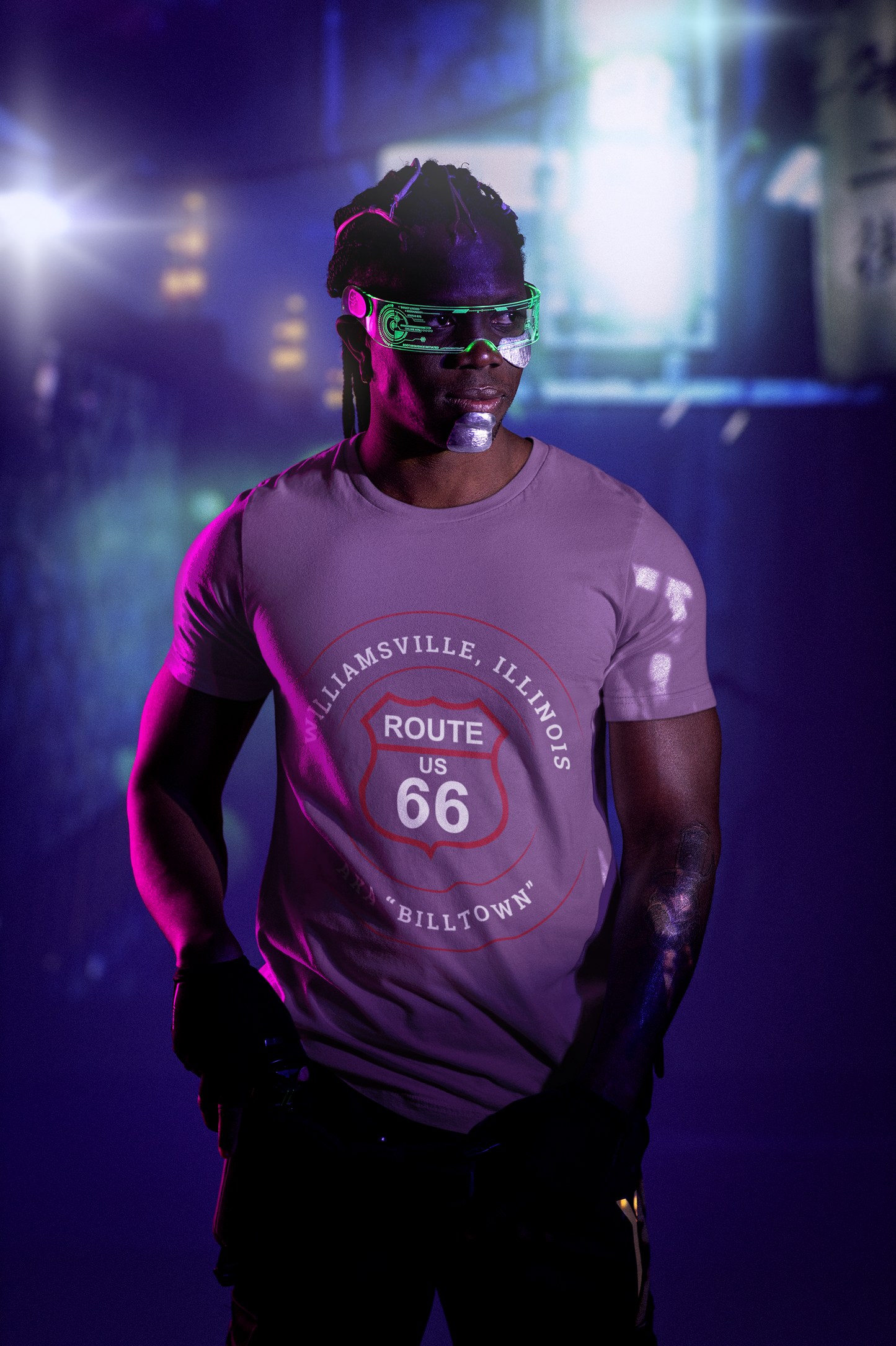 Male model wearing a heather team purple retro Route 66 unisex jersey tee with a Williamsville, IL: "AKA Billtown" design